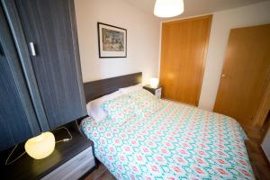 Dormitorio pequeño con cama y lámpara en Apartamento Voramar, en Daimuz