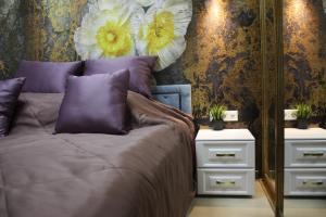 トゥーラにあるApartment on Demonstratsiiのベッドルーム1室(紫色の枕と鏡付きのベッド1台付)