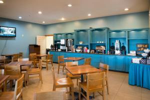 a restaurant with blue cabinets and wooden tables and chairs at Country Inn & Suites by Radisson, Effingham, IL in Effingham