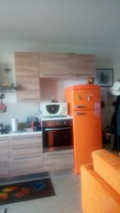 una cucina con frigorifero arancione e piano cottura di Appartamento Comodo a Pisa