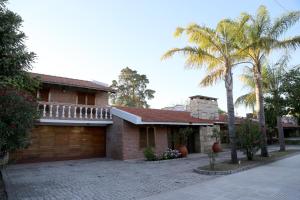 una casa de ladrillo con garaje y palmeras en Espectacular casa en Córdoba