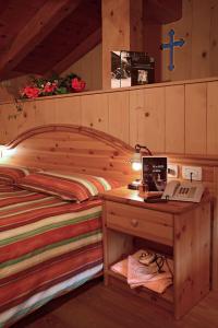 a bedroom with a bed and a desk with a laptop at Hotel Garni Plueme in Sauris