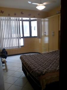 1 dormitorio con 1 cama en una habitación con ventanas en Apartamento Arraial Do Cabo, en Arraial do Cabo