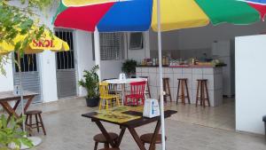 a table with a colorful umbrella in a kitchen at Suítes Eu in Caraguatatuba
