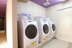 a row of white washing machines in a laundry room at Hotel Wing International Select Nagoya Sakae in Nagoya