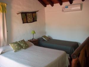 Casitas Volver a Nacer في كاربينتيريا: غرفة نوم بسريرين ومصباح ونافذة