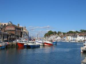 a group of boats are docked in a harbor at The Crown Hotel in Weymouth