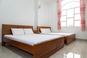 2 camas num quarto com 2 janelas em Song Hung Hotel em Cà Mau