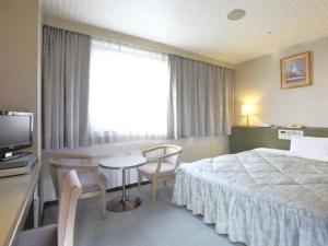 Habitación de hotel con cama, mesa y sillas en Pulses Inn Kyoto en Kyoto