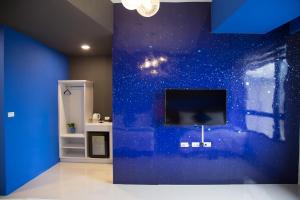 um quarto com uma parede azul e uma televisão de ecrã plano em BUDDY 35 em Jian