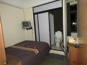 a small bedroom with a bed and a tv in it at Hostal El Eden in Zacatlán
