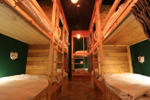 two bunk beds in a room with wooden walls at KO Hostel Kenting 返璞歸真 墾丁背包客棧 in Kenting
