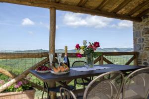 una mesa con un bol de fruta y flores en el balcón en Special and Nice close to the Chianti en Bucine