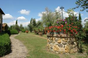 eine Steinmauer mit Blumen im Garten in der Unterkunft Piè di Costa in Montaione