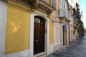 a yellow building with a brown door on a street at Casa Mia in Siracusa