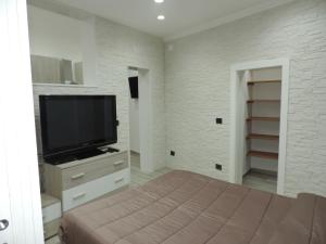 a bedroom with a flat screen tv and a bed at La Casetta in Leporano