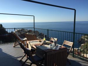 un tavolo e sedie su un balcone con vista sull'oceano di La Terrazza di Peun a Manarola