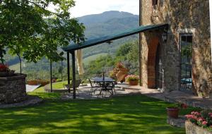 a patio with a table and chairs in a yard at Special and Nice close to the Chianti in Bucine