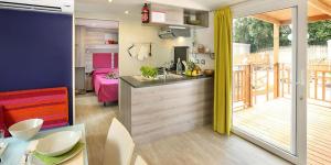 a kitchen with a dining table and a kitchen with a balcony at Camping villaggio L'Ultima spiaggia in Bari Sardo