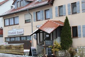 een gebouw met een bord ervoor bij Gasthof Rössle Ochsenwang in Bissingen an der Teck