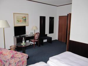 a hotel room with a bed and a desk at Hotel Wettin in Treuen