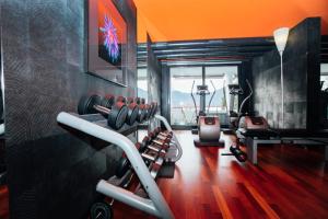 a gym with cardio equipment in a room with orange walls at Post Hotel Weggis in Weggis