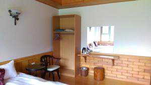 a bedroom with a bed and a table and a window at Seasons Inn in Jiaoxi