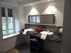 uma casa de banho com 2 lavatórios e um espelho grande em Lodge Hôtel de Sommedieue Verdun em Sommedieue