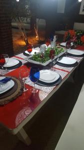 a table with plates and wine glasses on it at Rancho da Doris in Barra de São Miguel