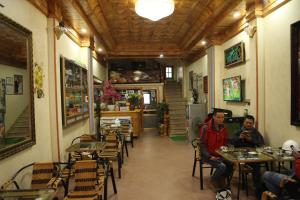 two people sitting at tables in a restaurant at Thien Phuong Guesthouse in Sa Pa +48 photos
