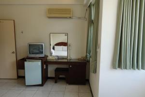 a room with a desk with a television and a mirror at Fa Tai An Homestay in Guangfu