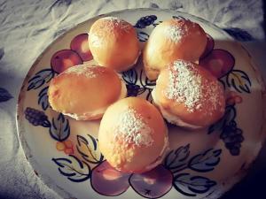a plate of buns with powdered sugar on it at b&b Bellavista in Castro di Lecce