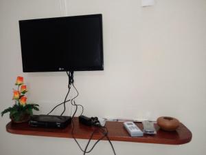 TV de pantalla plana colgada en la pared en Pousada Chalé Mar Rio, en Galinhos