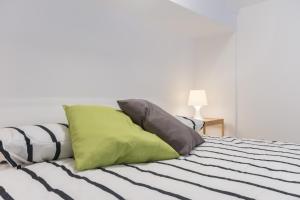 トリノにあるMoleloca - Casa Artisti 7のベッド(緑とグレーの枕付)