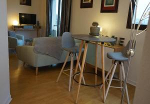 ブリーヴ・ラ・ガイヤルドにあるFRERES LUMIERES #2 - Studio Cocooning - 2 personnesのリビングルーム(テーブル、椅子、ソファ付)