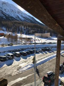 a parking lot with cars parked in the snow at Appartement Montgenevre pied de pistes in Montgenèvre