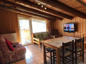 a living room with a wooden table and a couch at Appartement Montgenevre pied de pistes in Montgenèvre