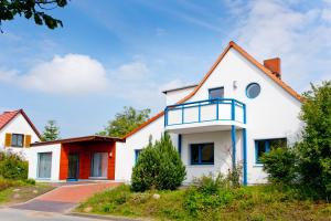 ein weißes Haus mit einem roten Dach in der Unterkunft Ferienwohnungen Ostrea & Rugia in Breege