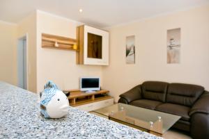 ein Wohnzimmer mit einem Sofa und einem ausgestopften Tier auf der Theke in der Unterkunft Ferienwohnungen Ostrea & Rugia in Breege