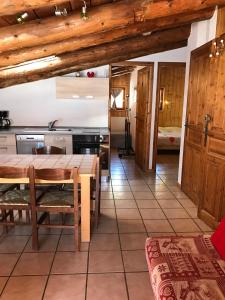 a kitchen and dining room with wooden ceilings and a table at Appartement Montgenevre pied de pistes in Montgenèvre