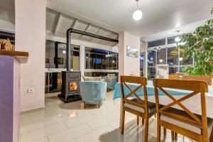 a living room with a fireplace and a table and chairs at Nefes Hotel in Ayvalık