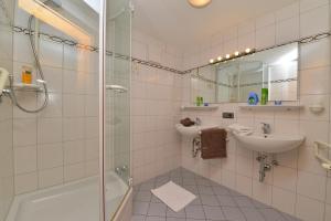 een badkamer met douche, wastafel en spiegel bij Ferienwohnungen Thannheimer in Oberstdorf +11 foto's
