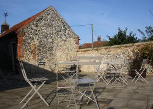 a group of chairs and tables in front of a stone building at The Three Horseshoes in Warham