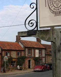 a red car parked in front of a building at The Three Horseshoes in Warham