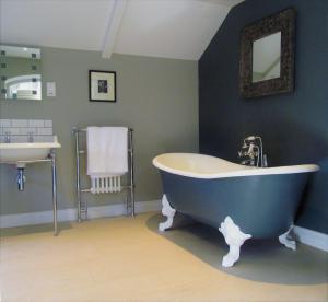 a blue bathroom with a tub and a sink at The Three Horseshoes in Warham