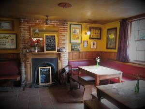 a living room with a fireplace and a table and a fire place at The Three Horseshoes in Warham