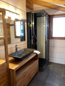 uma casa de banho com um chuveiro e um lavatório. em Chalet Luxe Les Mélèzes em Samoëns