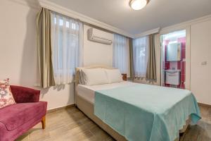 a bedroom with a bed and a red couch at Nefes Hotel in Ayvalık