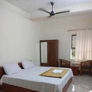 a bedroom with a bed and a ceiling fan at Manjira Lodge in Guruvāyūr