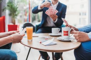 a group of people sitting around a table with coffee cups at Ibis Mohammedia in Mohammedia